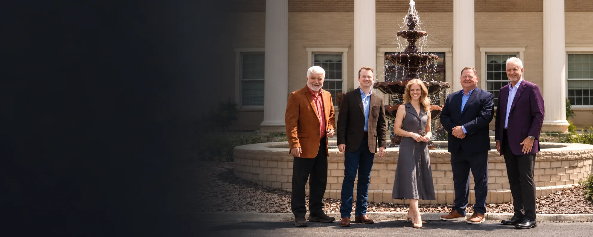Price Richards team standing in front of a fountain outside a columned building
